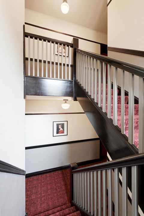 a stairwell with black and white stairs and a picture on the wall