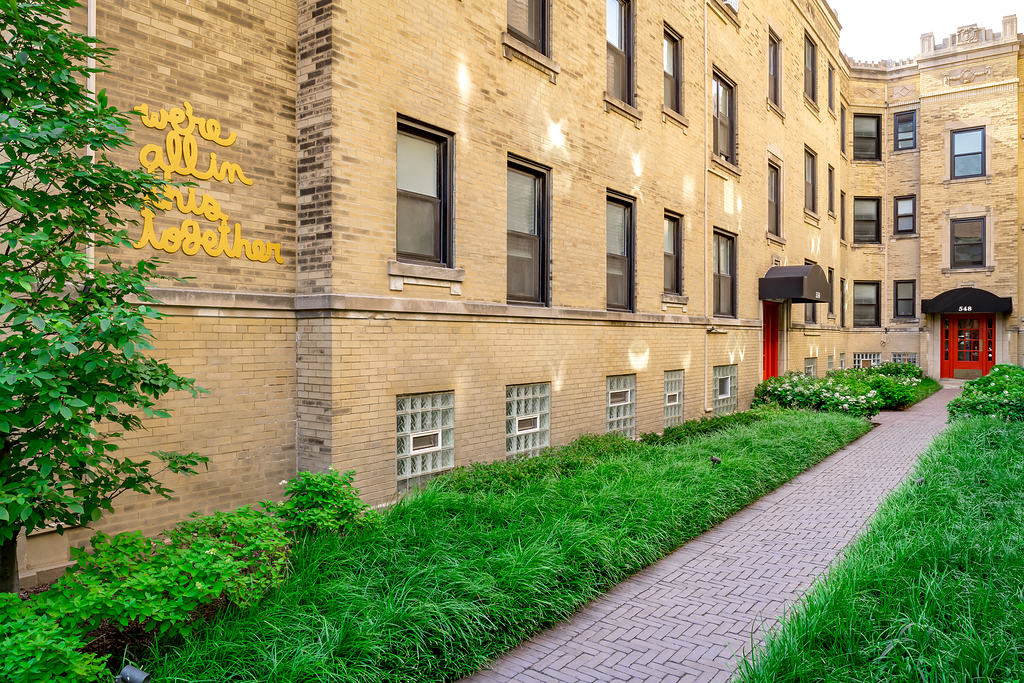 a brick building with a sidewalk in front of it