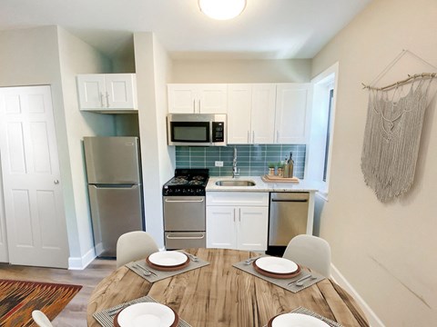 a kitchen with stainless steel appliances and a wooden table