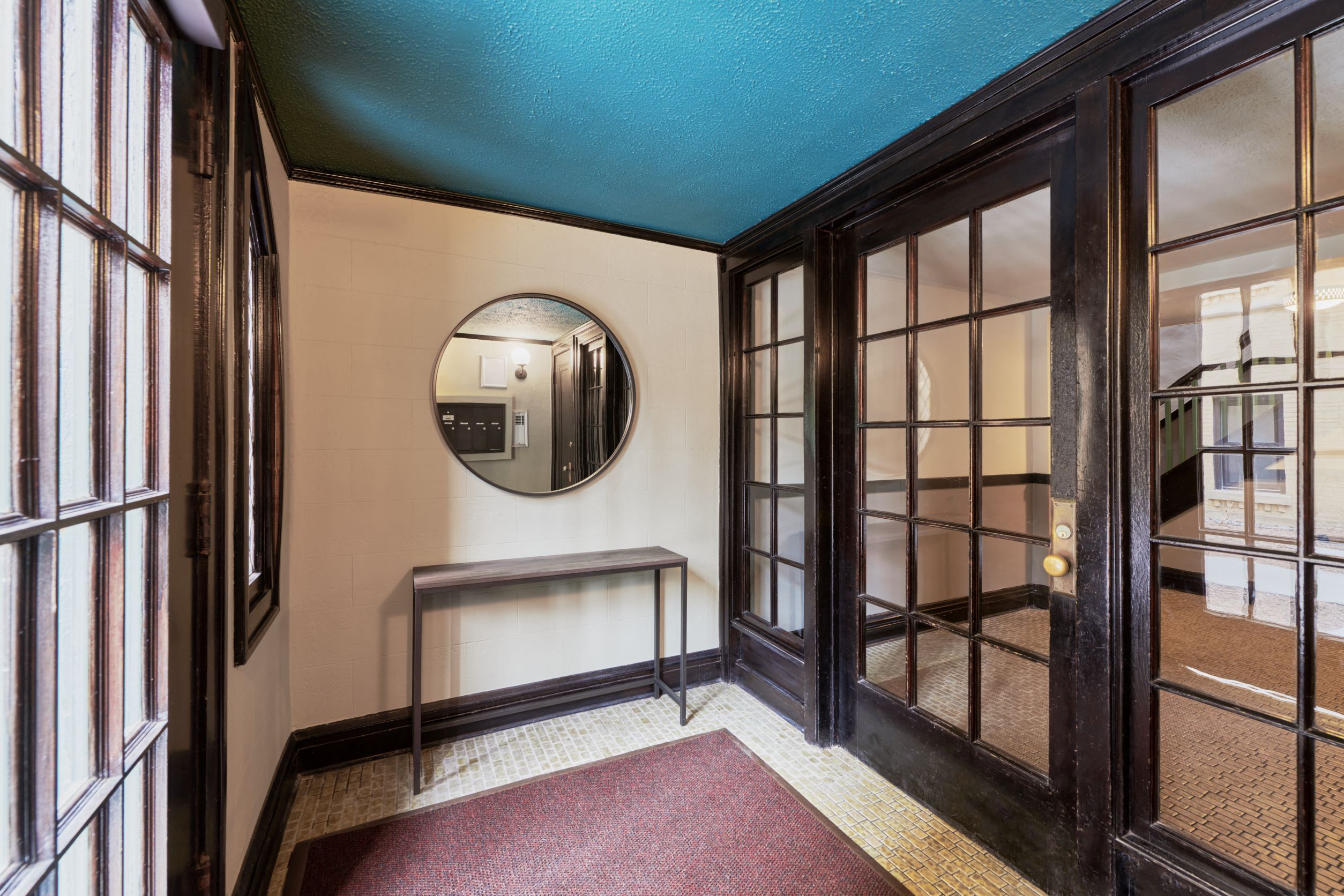 a hallway with glass doors and a mirror
