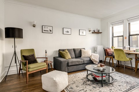 a living room with a gray couch and a glass coffee table