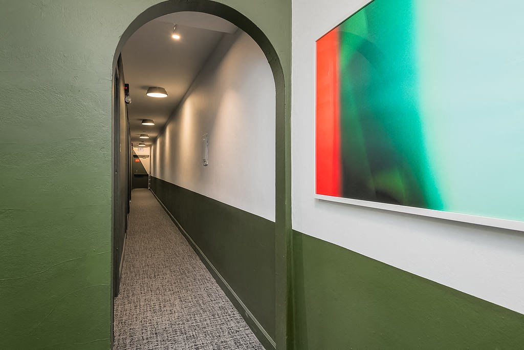 a hallway with green and white walls and an arched doorway