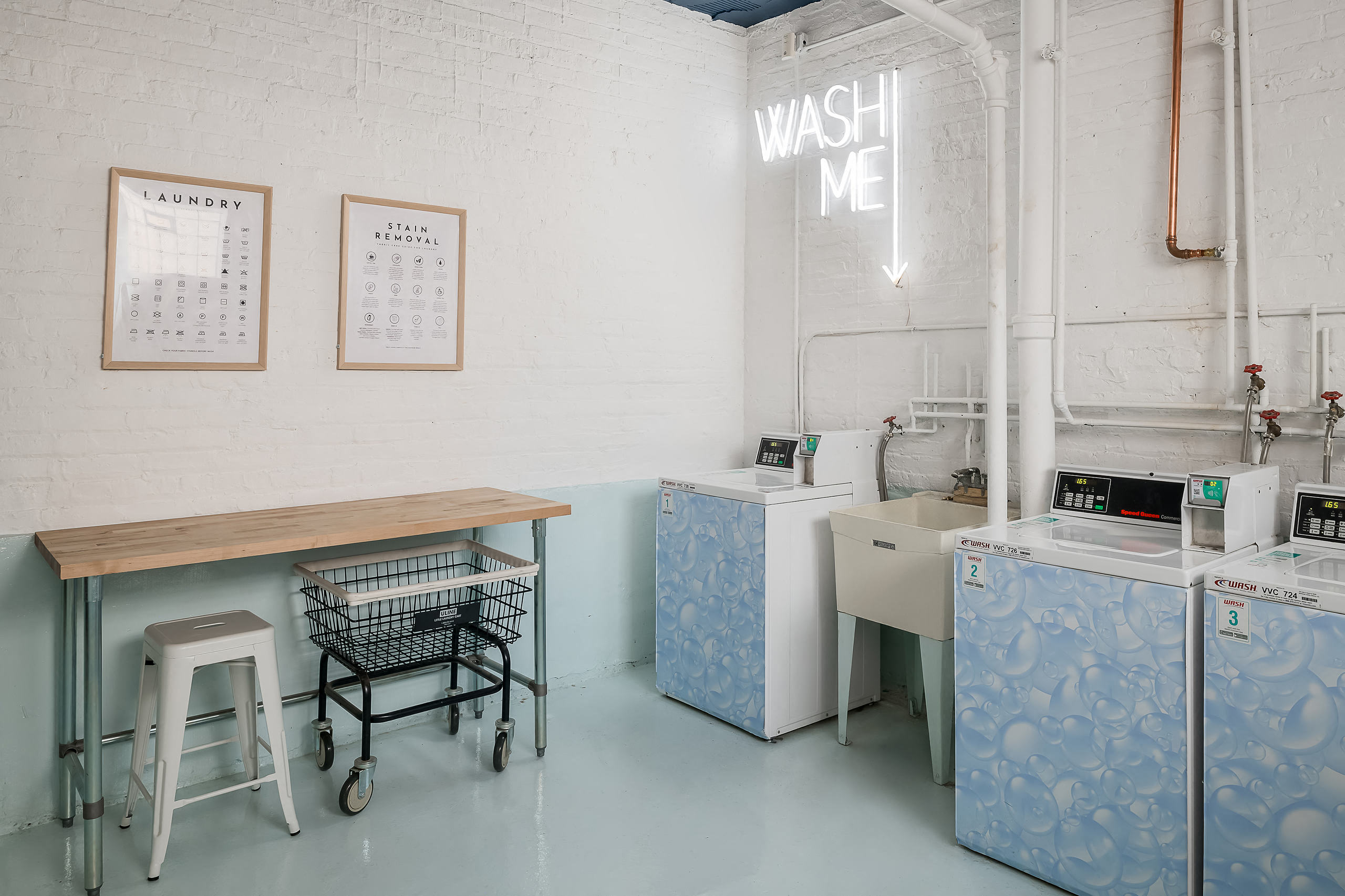 a laundry room with a washing machine and a desk with a chair