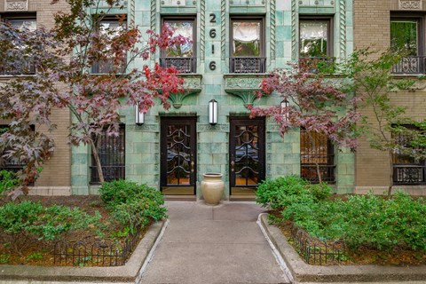 A green building with a black gate and a large door.