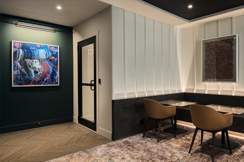 a dining room with a table and chairs and a painting on the wall