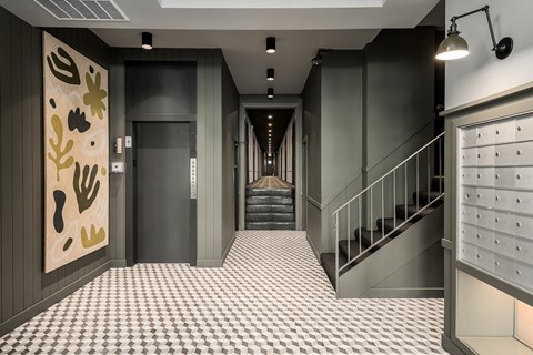 a hallway with stairs and a checkered floor and a view of a hallway