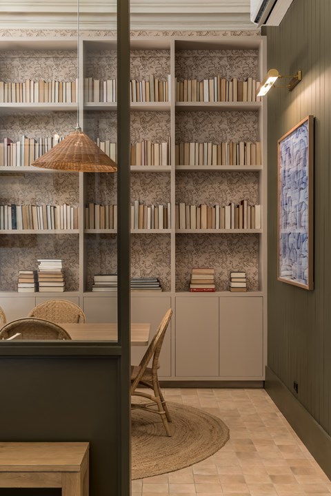 A room with a bookshelf, a chair, and a rug.