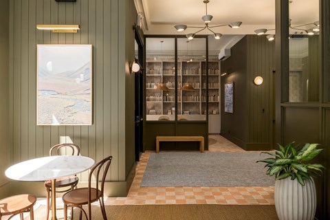 A room with a table and chairs and a bookshelf.
