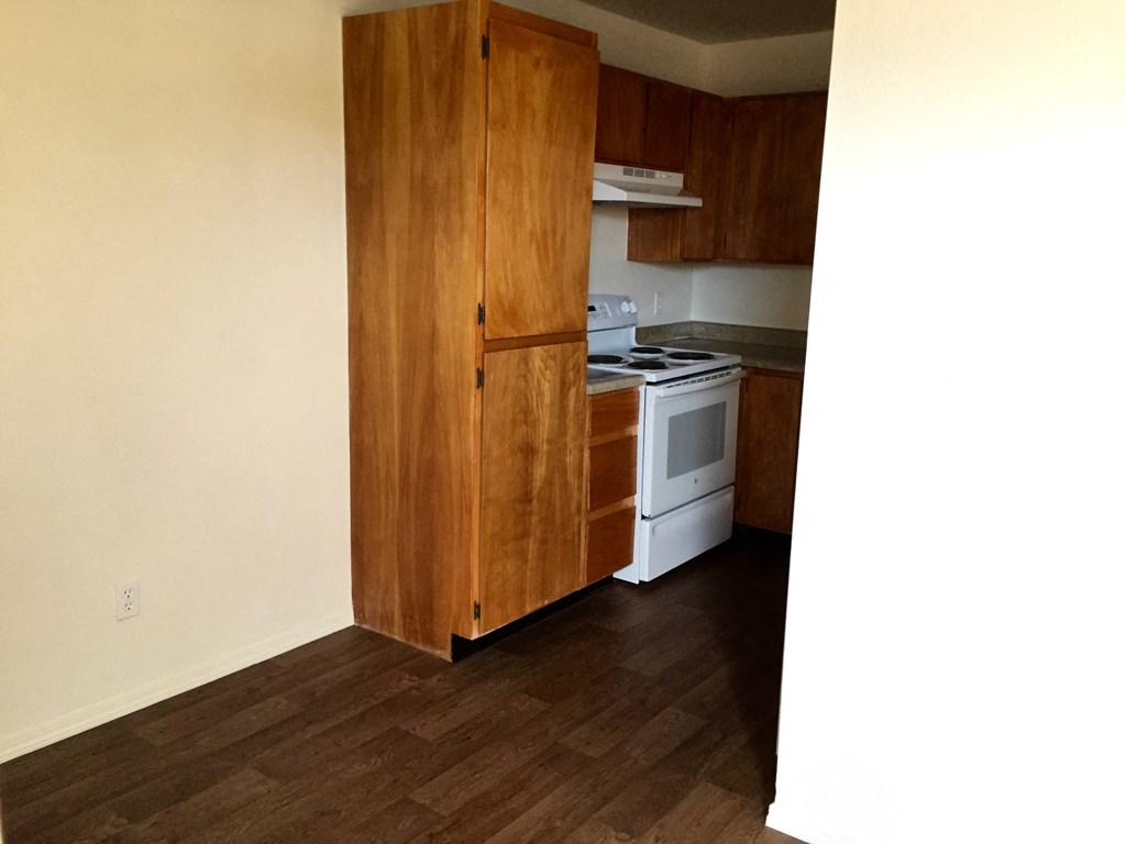 an empty kitchen with a stove and a refrigerator