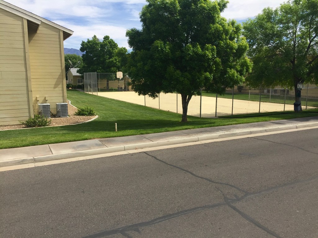 a street with trees and a fence on the side of a house