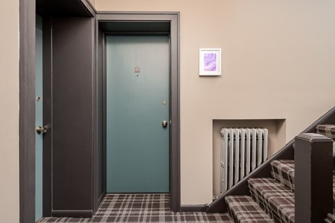 the door to a room with stairs and a green door