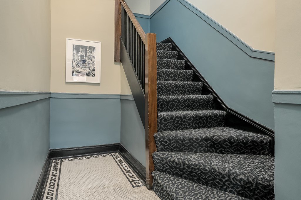 a staircase with carpeted steps and blue walls and a wooden door