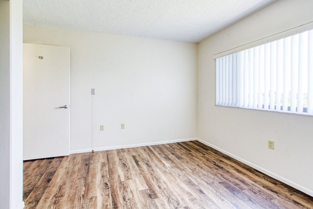bedroom with large window and hardwood-style flooring
