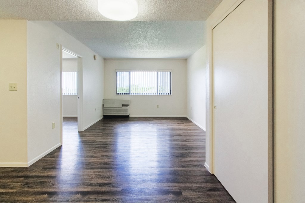 living room with overhead lighting, large window, and hardwood-style flooring