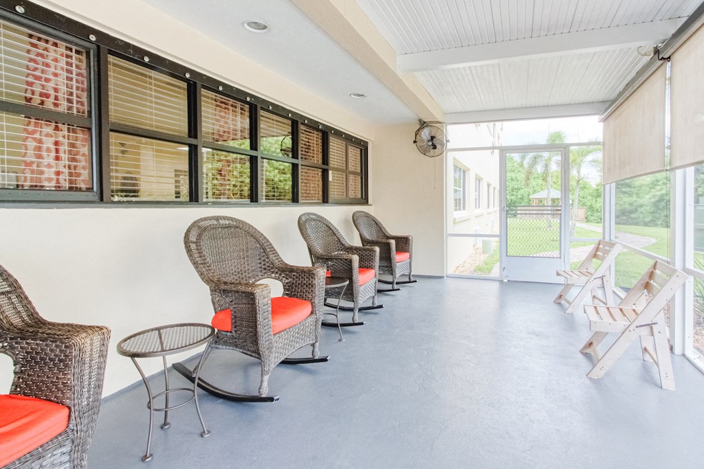 screened-in patio with rockers, chairs, and sun screens