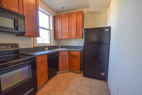 a kitchen with black appliances and wooden cabinets