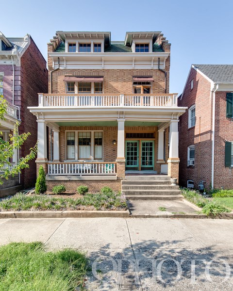 an old brick house with a balcony and a porch