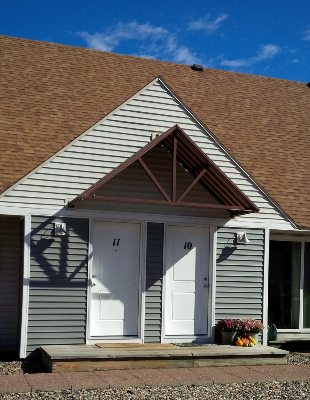 the front of a white house with two doors