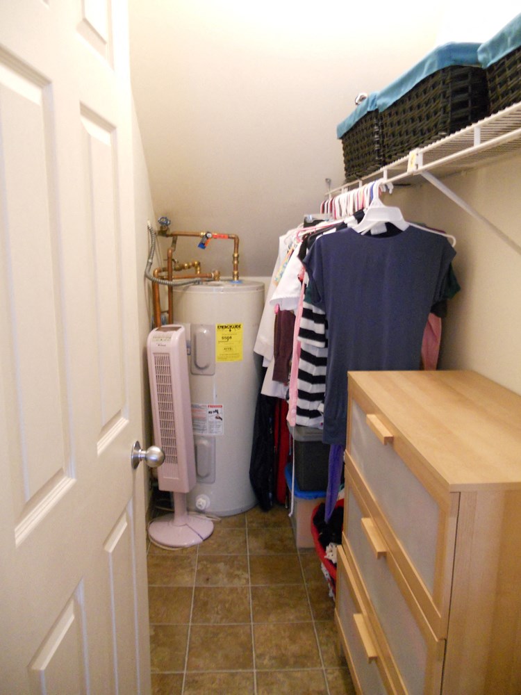 a small laundry room with a clothes rack and a washing machine