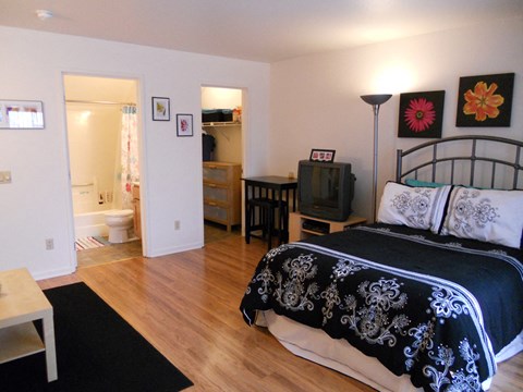 a bedroom with a bed and a bathroom with a toilet and a sink