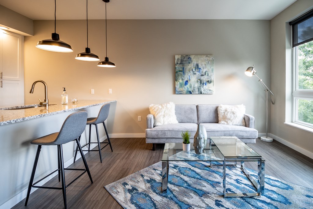 a living room with a couch and a kitchen with a bar