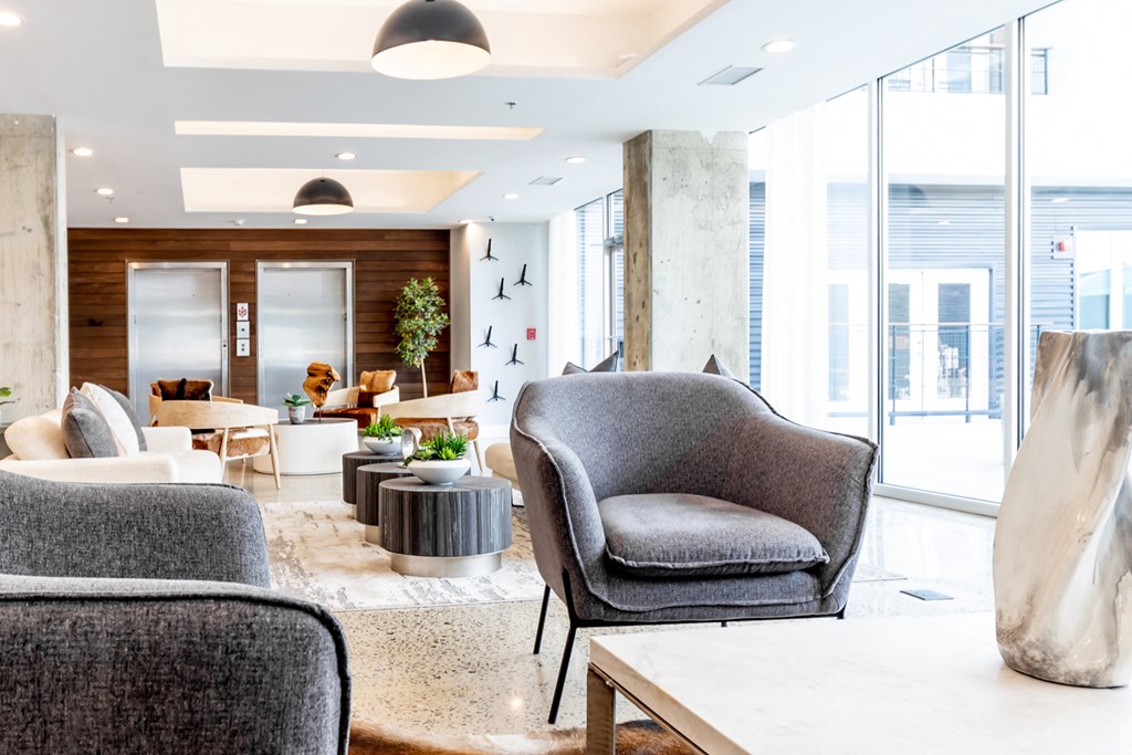a lobby with chairs and tables and a large window