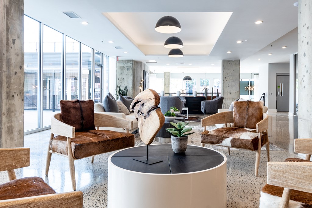 a living room with chairs and a table with a bird statue