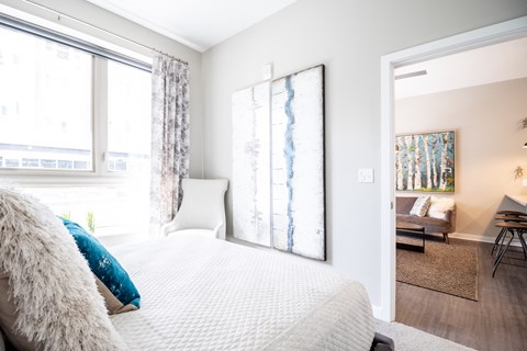a bedroom with a large bed and two windows