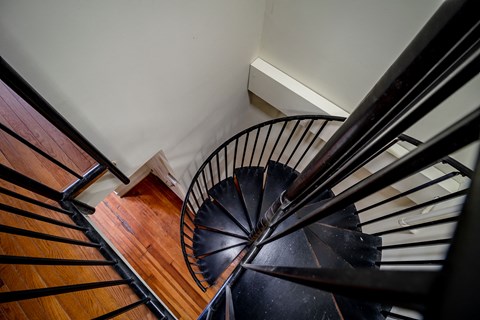 the spiral staircase is made of wood and black metal