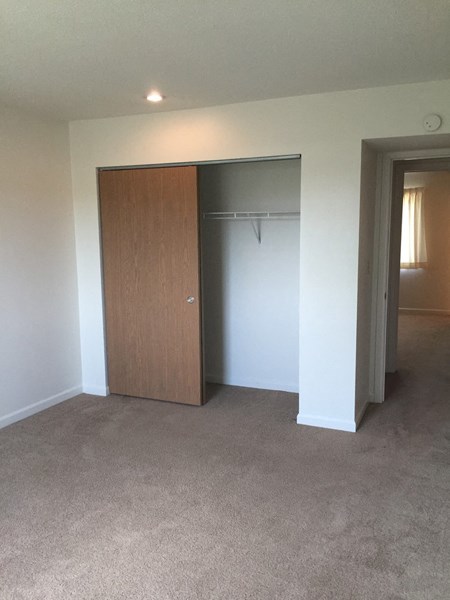 an empty living room with a door to a closet