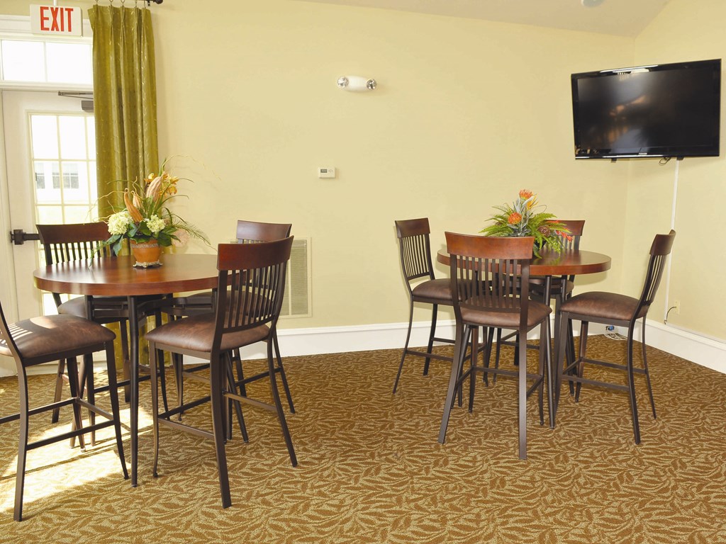 a dining area with a table and chairs and a television