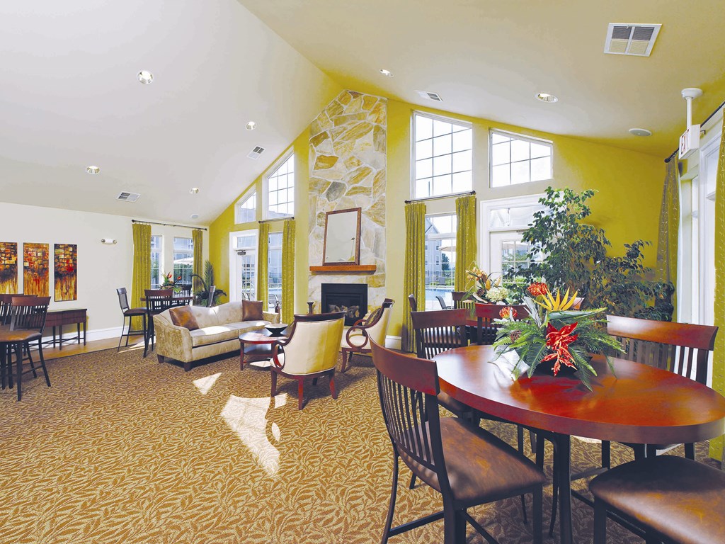 a large living room with a table and chairs and a fireplace