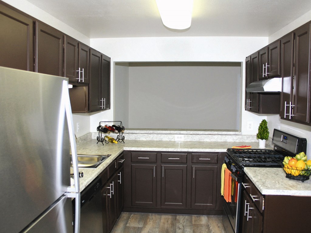 a large kitchen with dark cabinets and stainless steel appliances