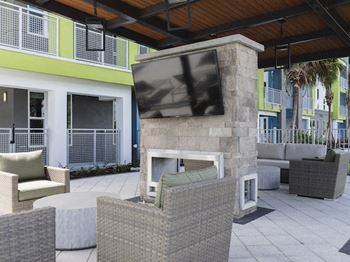 Outdoor fireplace and tv lounge at Residences at The Green Apartments in Lakewood Ranch, FL