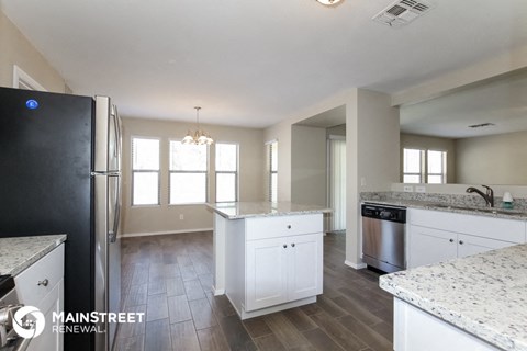 a large kitchen with white cabinets and stainless steel appliances