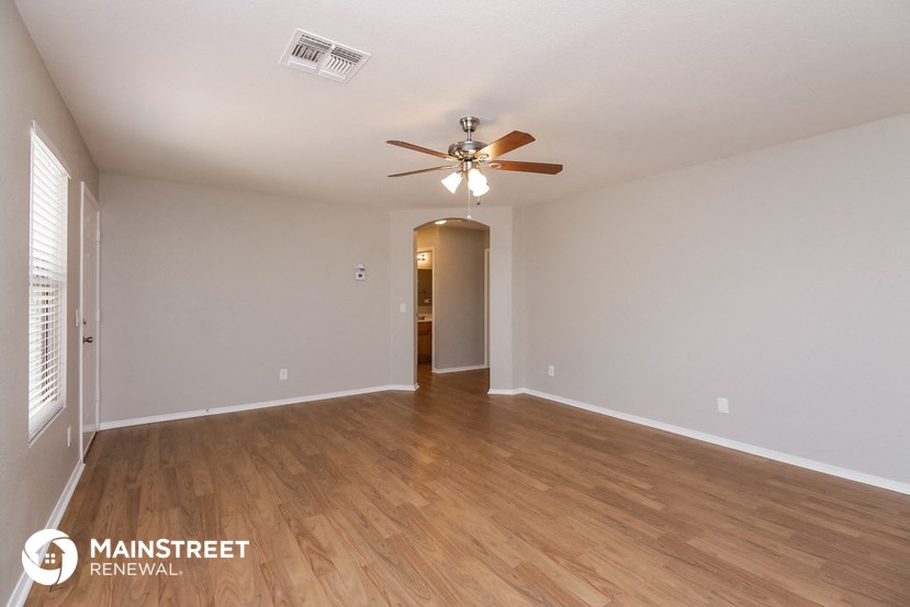 a living room with a ceiling fan and wood flooring