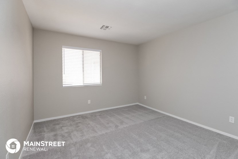 a bedroom with a carpeted floor and a window
