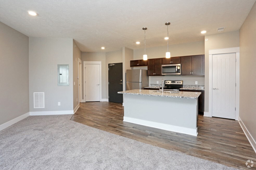 an open kitchen and living room with a large counter top