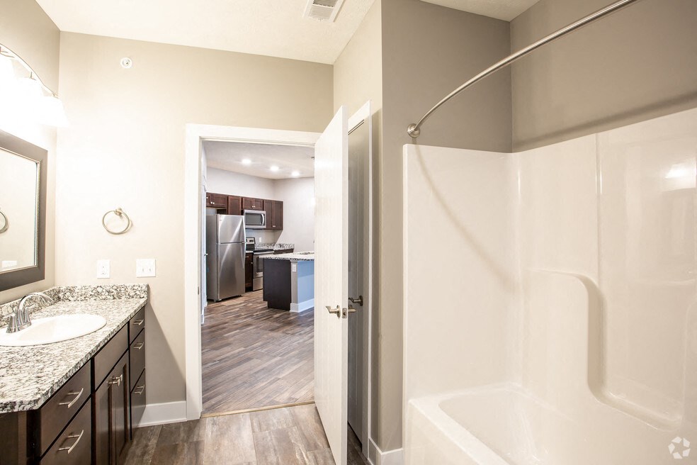 a bathroom with a shower and a sink and a mirror