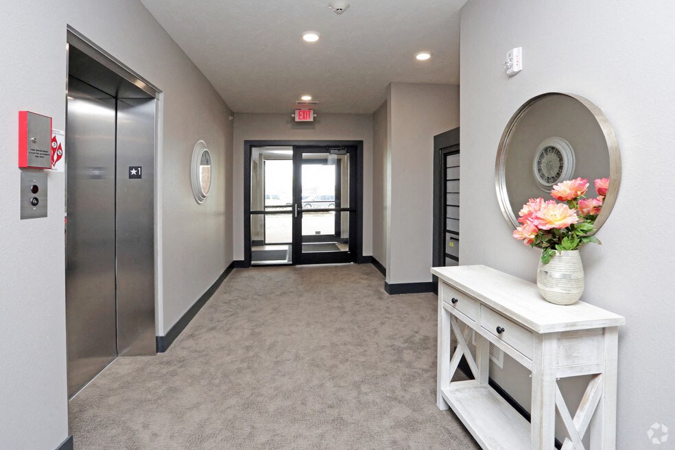 a hallway with a table and a vase with flowers on it and a door