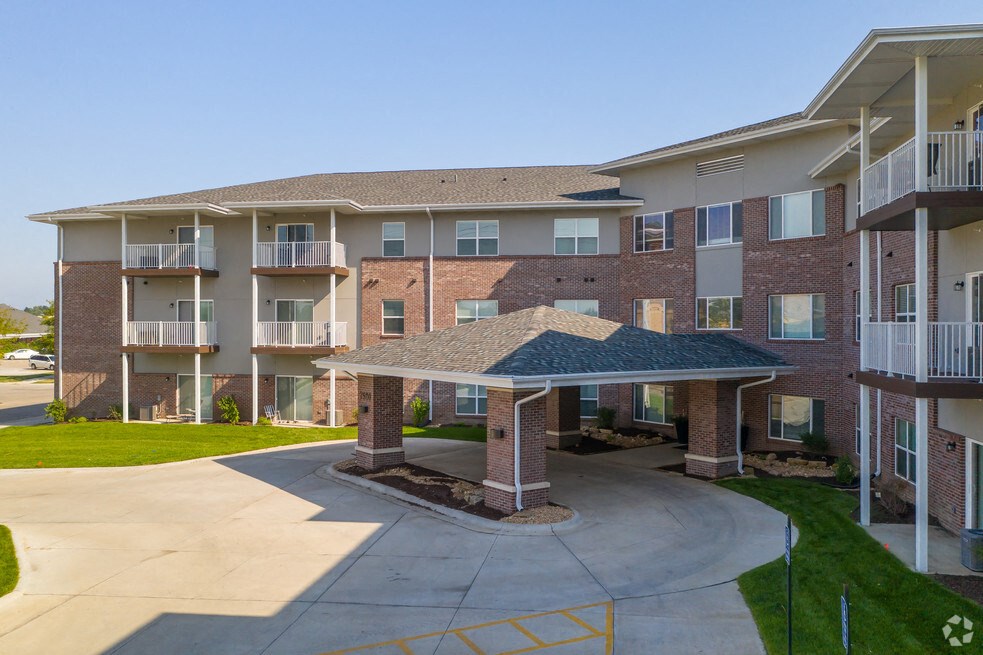 an exterior view of an apartment building with a driveway and awning