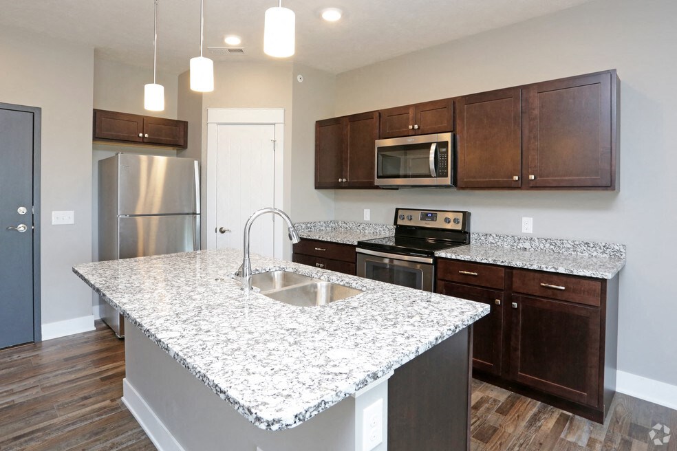 a kitchen with granite counter tops and wooden cabinets