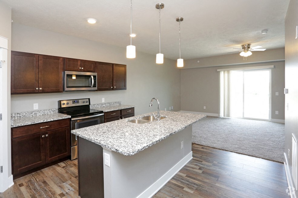 an empty kitchen with a marble counter top