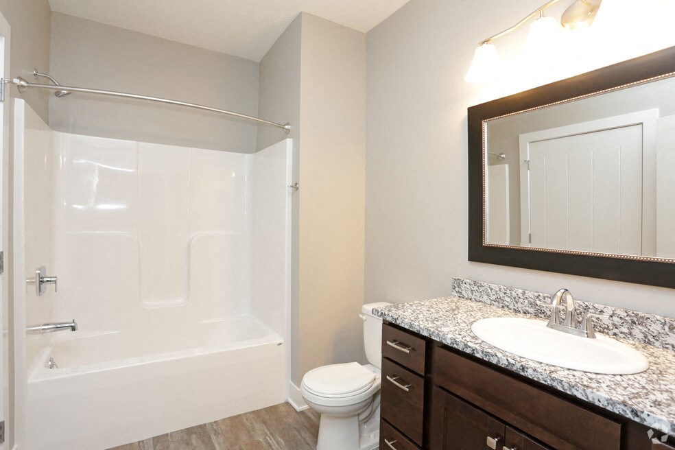 a bathroom with a shower sink and toilet and a mirror