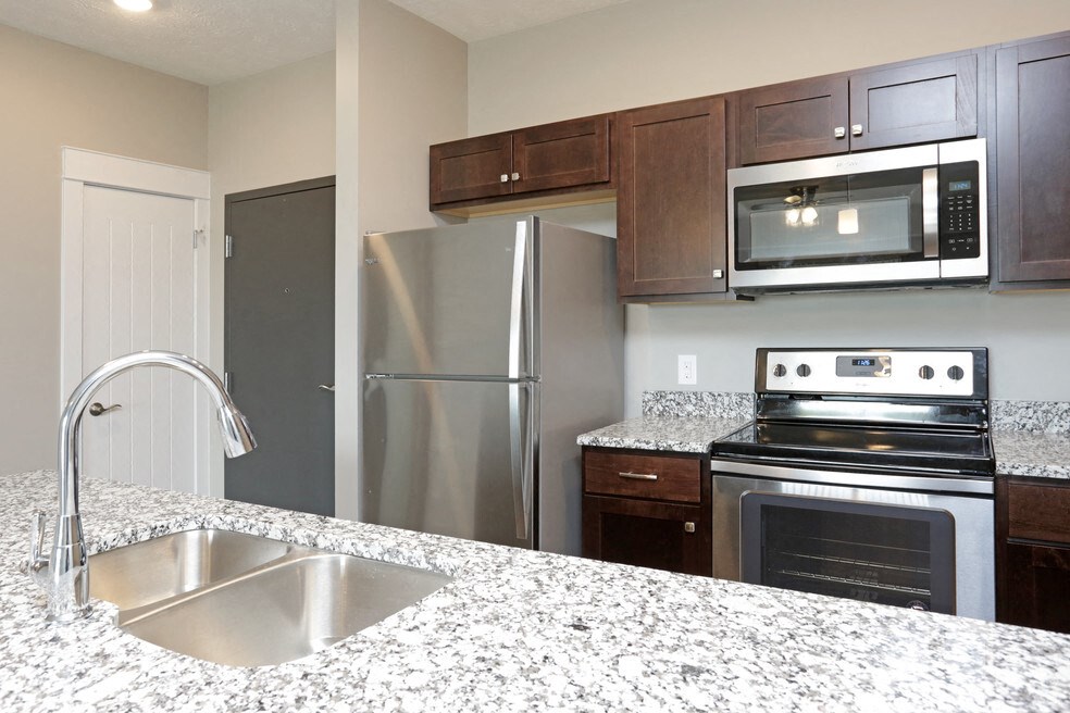 a kitchen with granite counter tops and stainless steel appliances