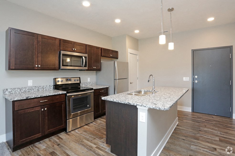 a kitchen with granite counter tops and wooden cabinets