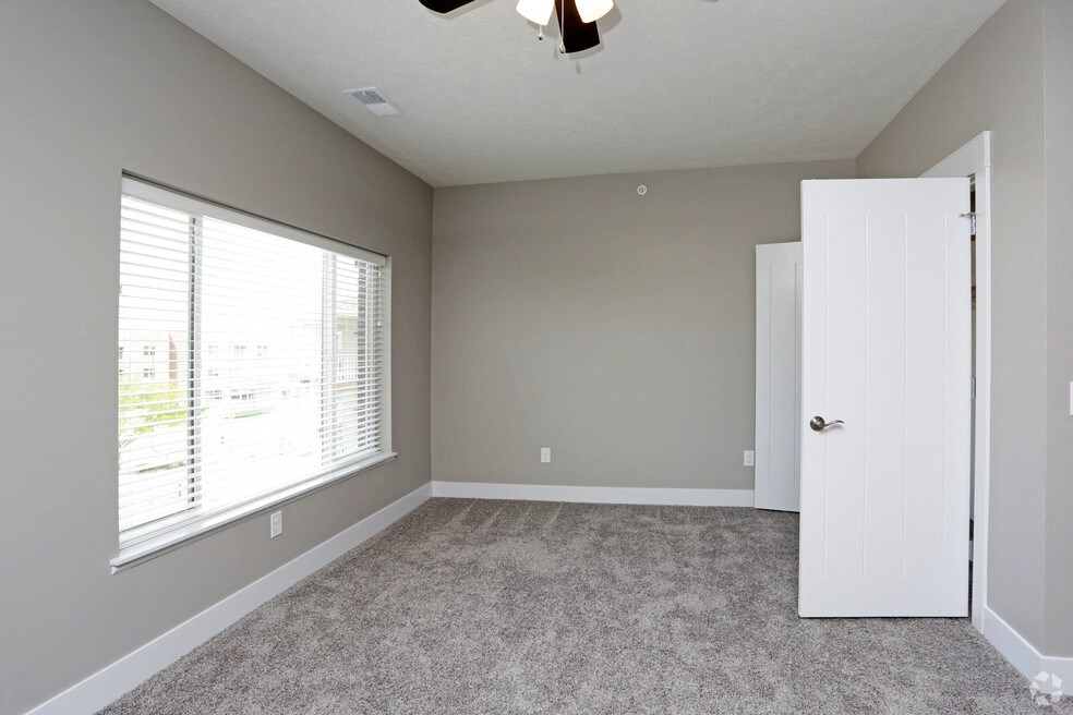 an empty room with a large window and a white door