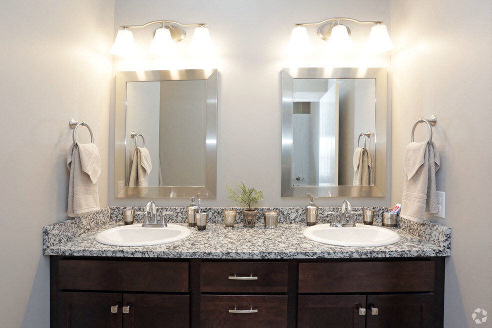 a bathroom with two sinks and two mirrors
