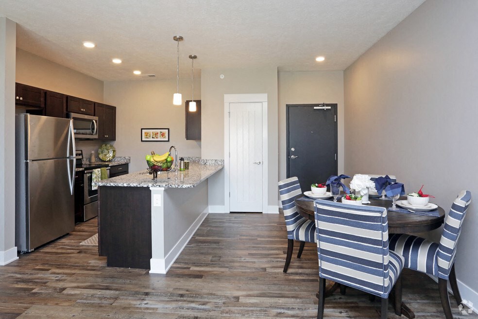 a kitchen and dining room with stainless steel appliances and a table and chairs