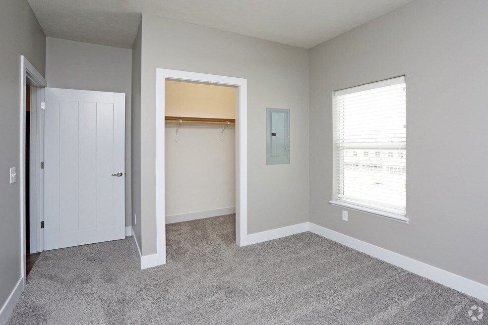 an empty bedroom with a closet and a window